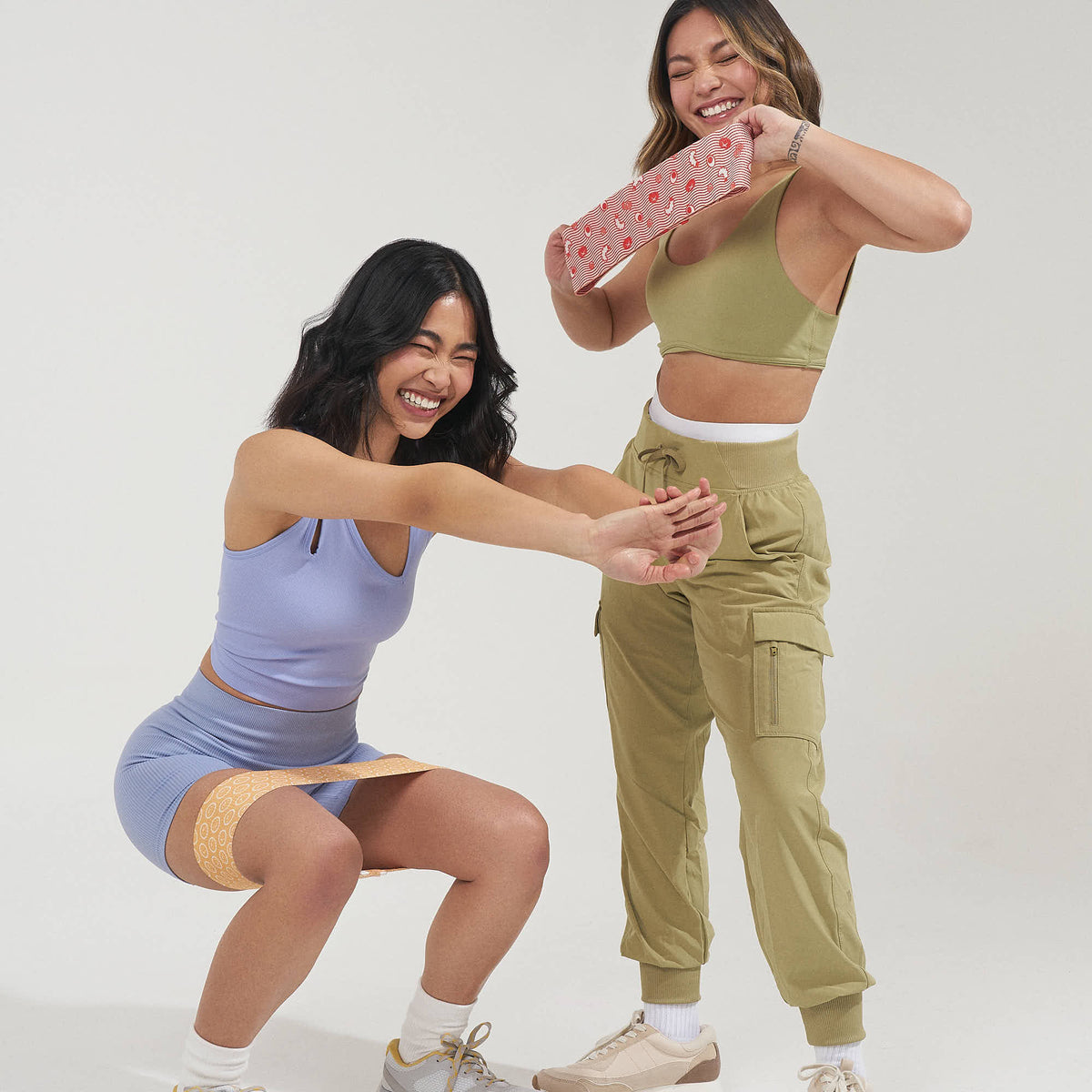 Two women squatting and stretching with MOMO glute bands
