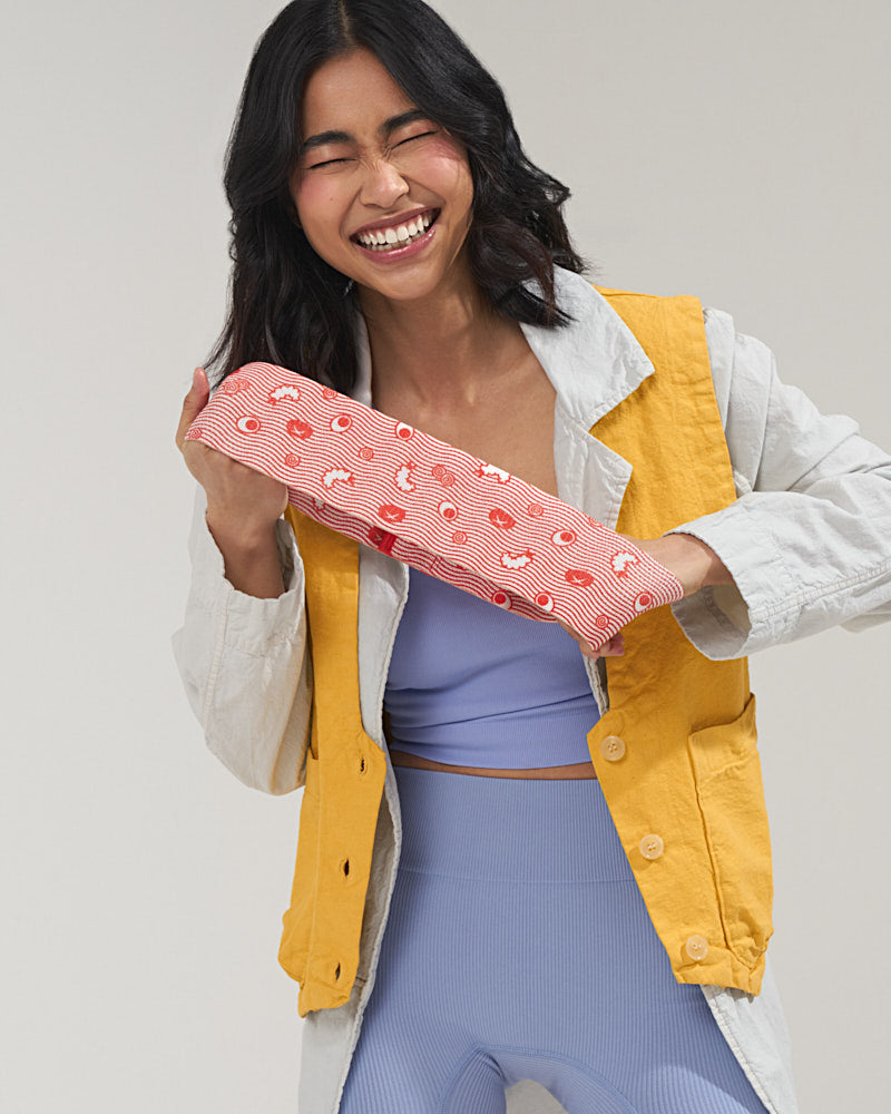 Asian girl laughing and stretching a red ramen design booty band