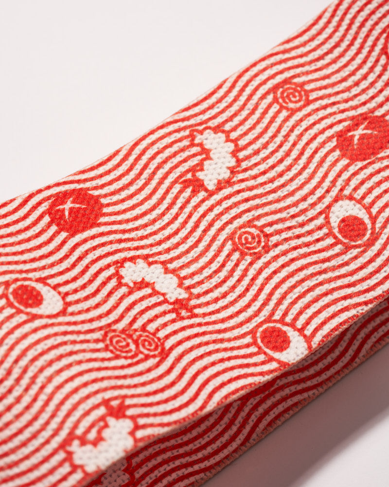 close up of Red ramen resistance band tamago, shiitake, tempura, and green onion artwork on it