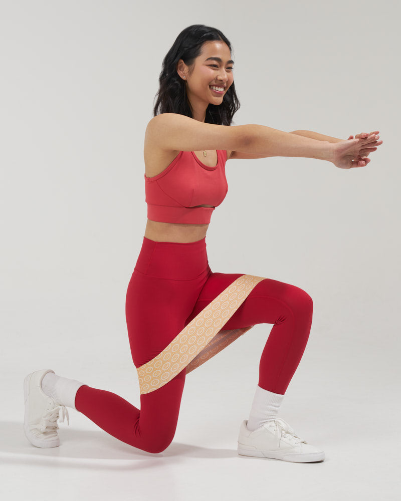 smiling girl demonstrating a leg lunge with a cute fabric resistance band