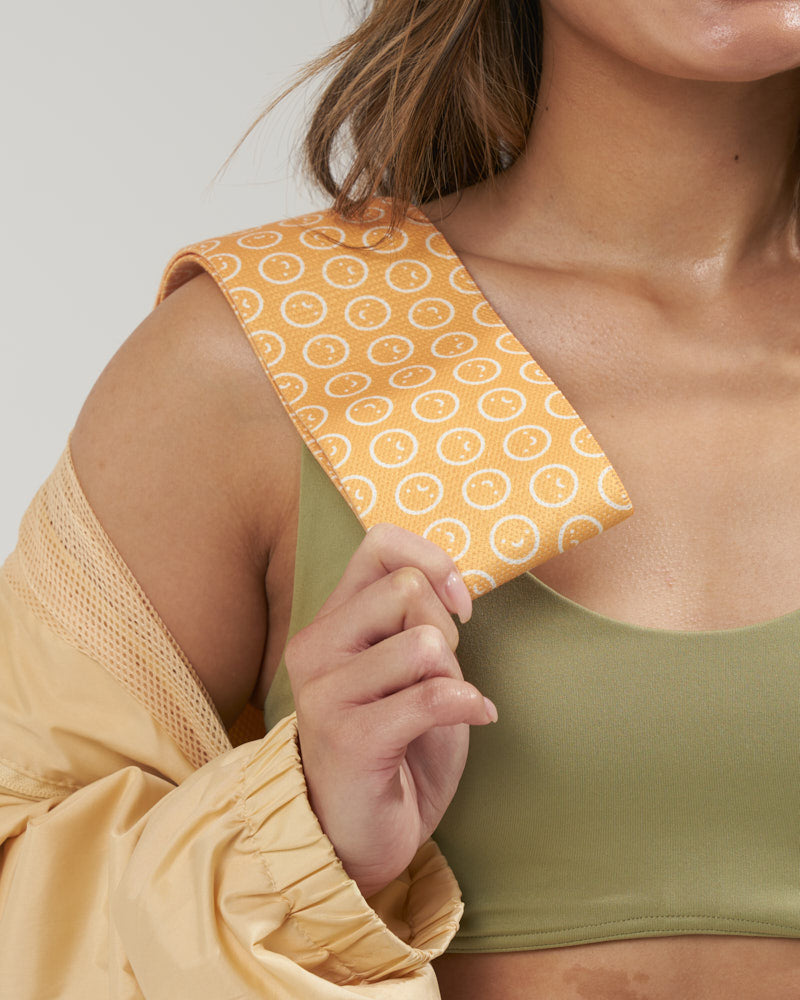 girl holding a smiley face resistance band across her shoulder