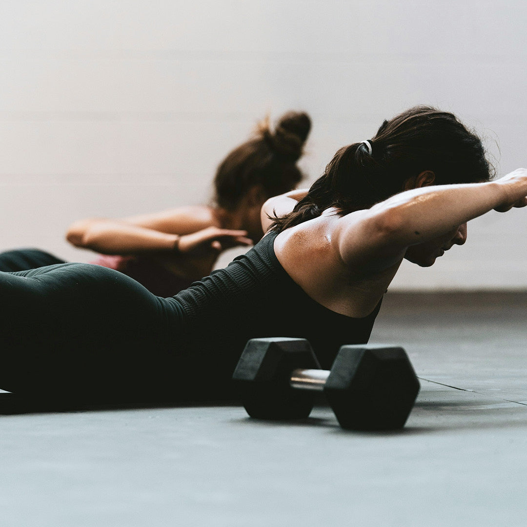 girl at the gym laying on the floor doing back exercises