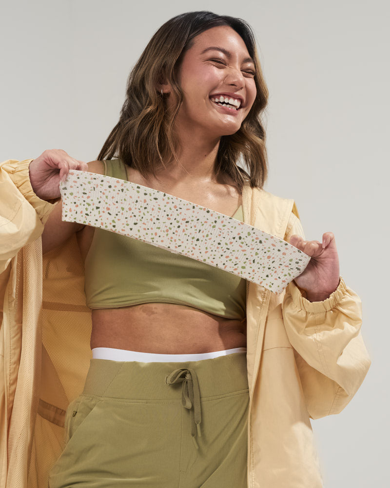 girl laughing and stretching a cute tan terrazo booty band