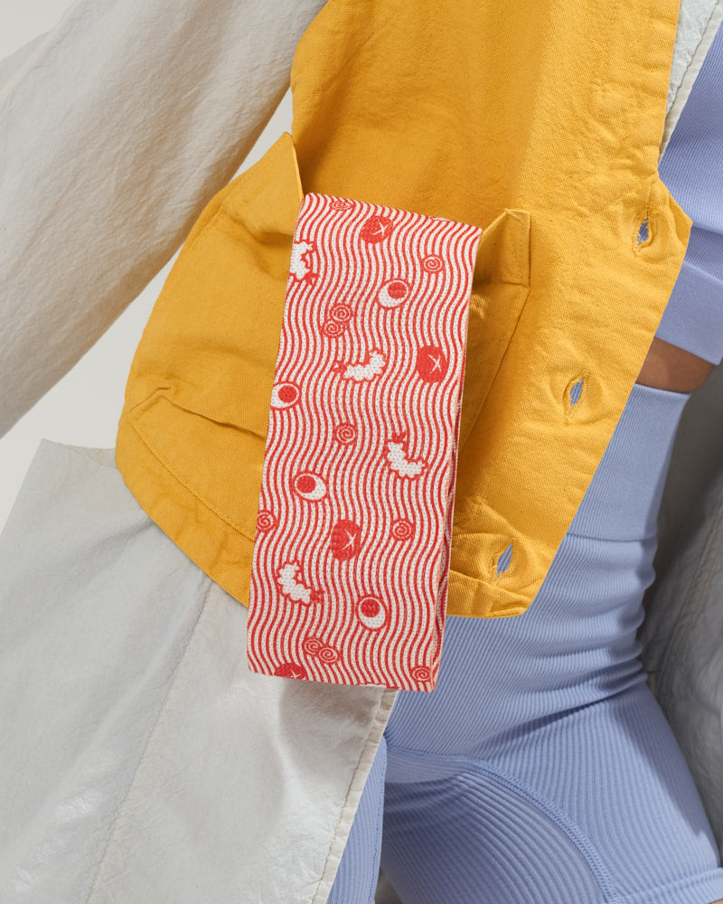 Close up of red ramen fabric resistance band posed with stylish athlesiure