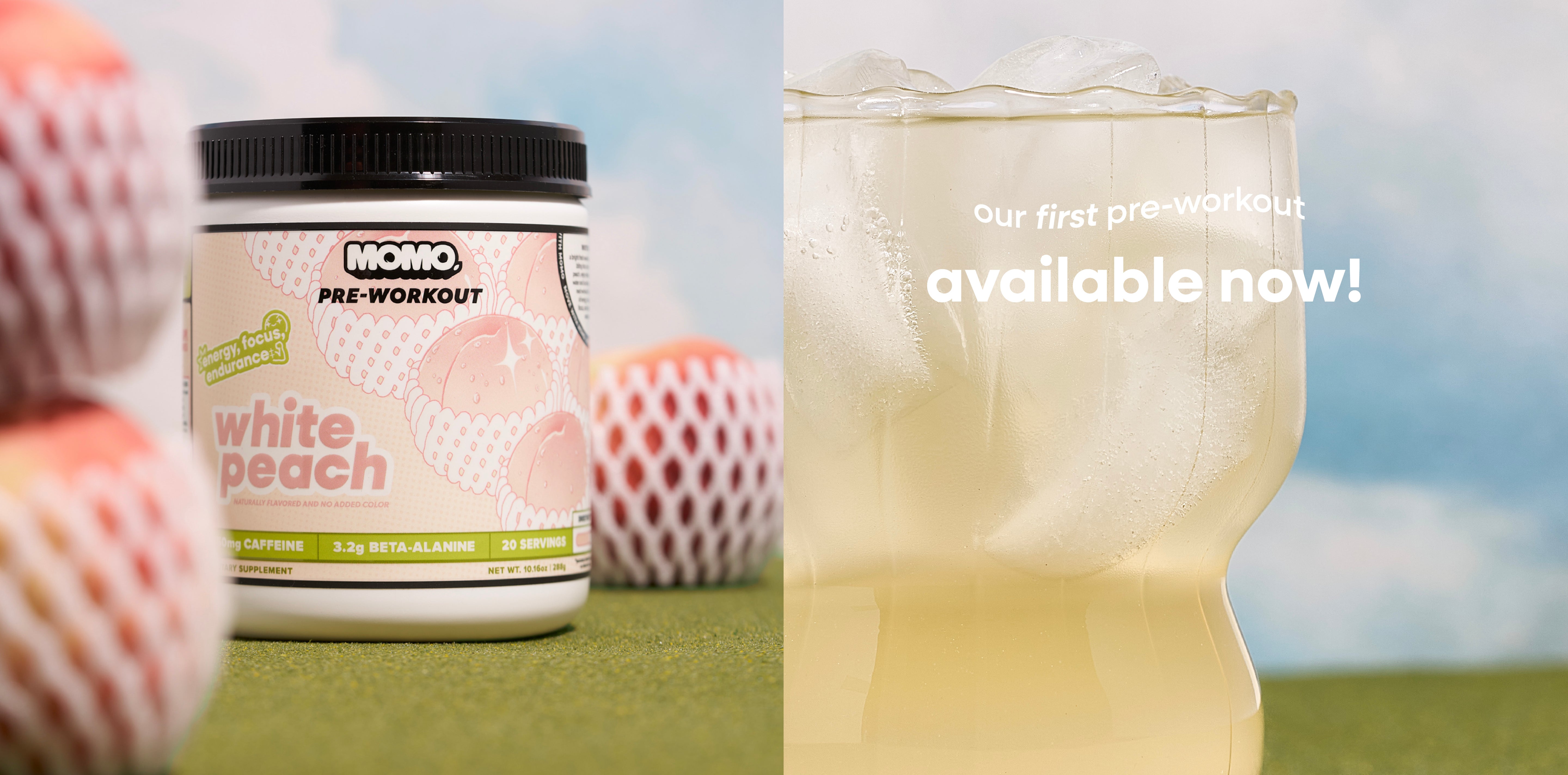 MOMO white peach pre workout in its packaging and in a refreshing glass of ice, all on grass with a blue sky, surrounded by peaches.