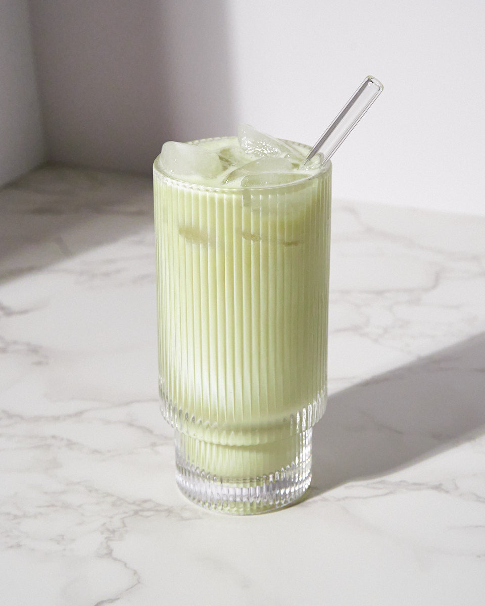 MOMO Matcha soft served flavored whey protein in a clear glass of ice