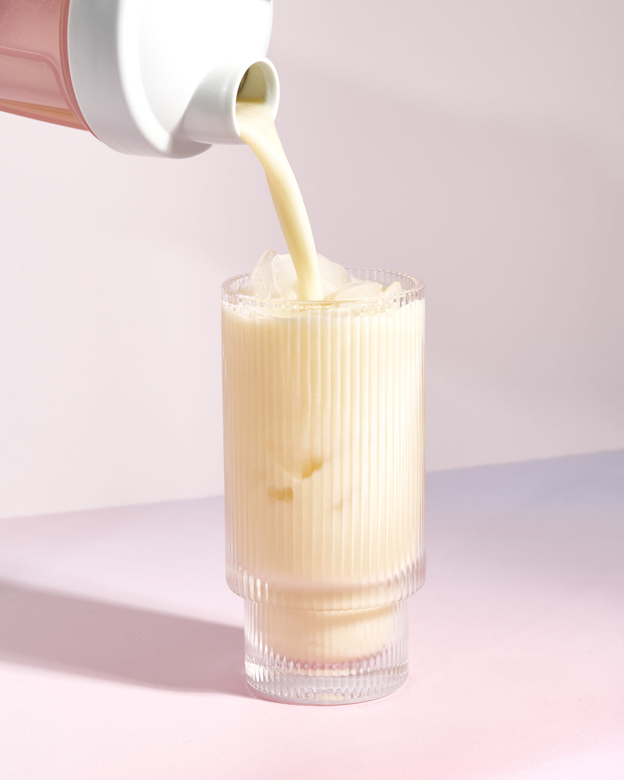 MOMO asian yogurt protein being poured into a clear glass of ice